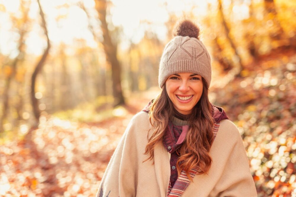 Femme marchant dans la forêt par une journée d'automne ensoleillée